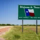 A scenic view of Texas with the sign of Welcome to Texas - A no income tax state