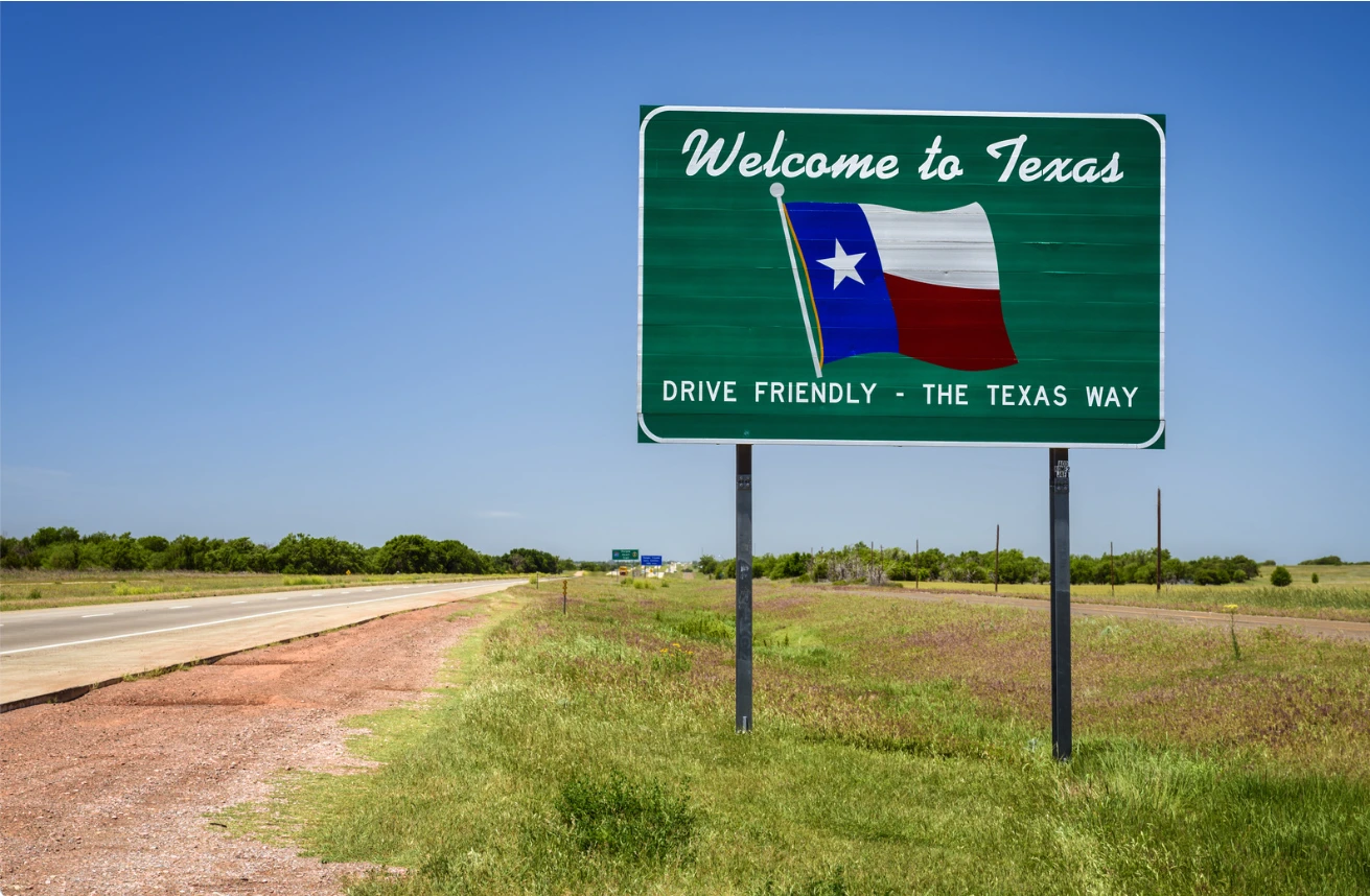 A scenic view of Texas with the sign of Welcome to Texas - A no income tax state